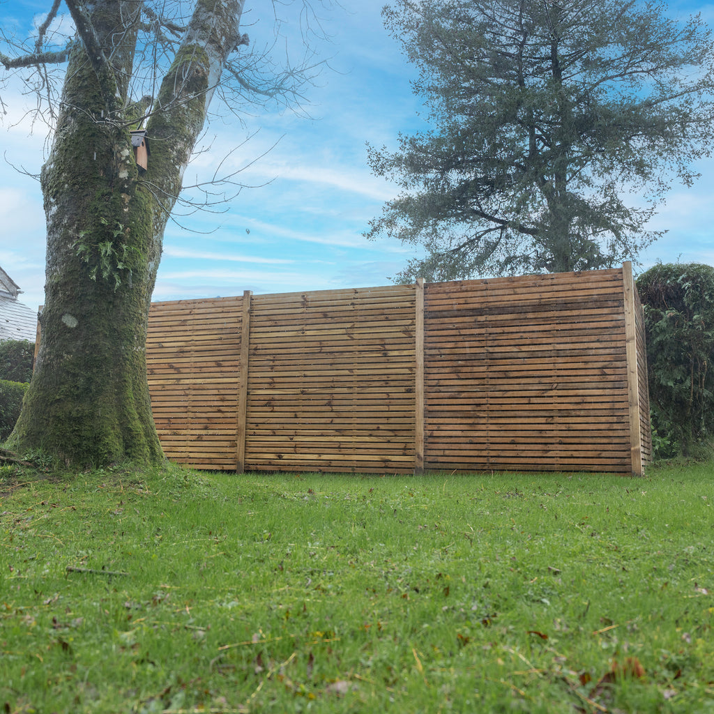 Lifestyle shot of double sided cedar slatted panels, installed in a garden