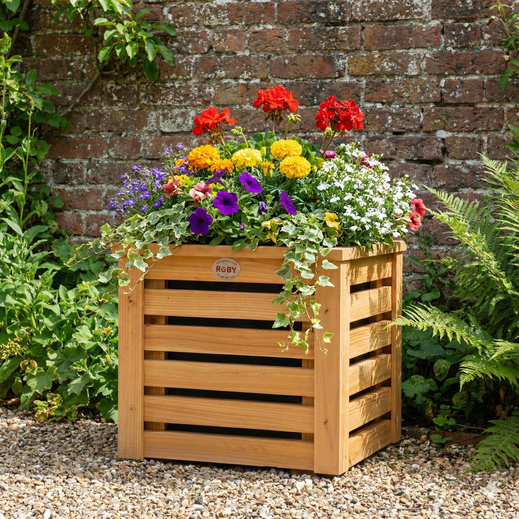 Lifestyle image of slatted planter installed in a garden, with flowers 