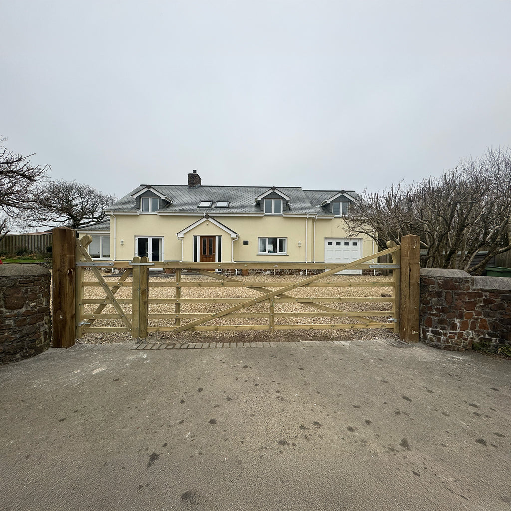 The Exbourne Curved Heel Planed Gate installed in brick wall entrance, displaying elegant proportions and natural timber finish