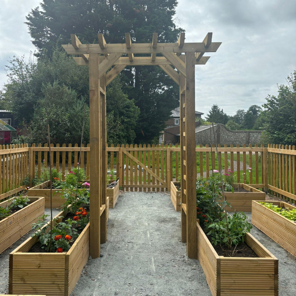 Abour with trellis installed in garden setting