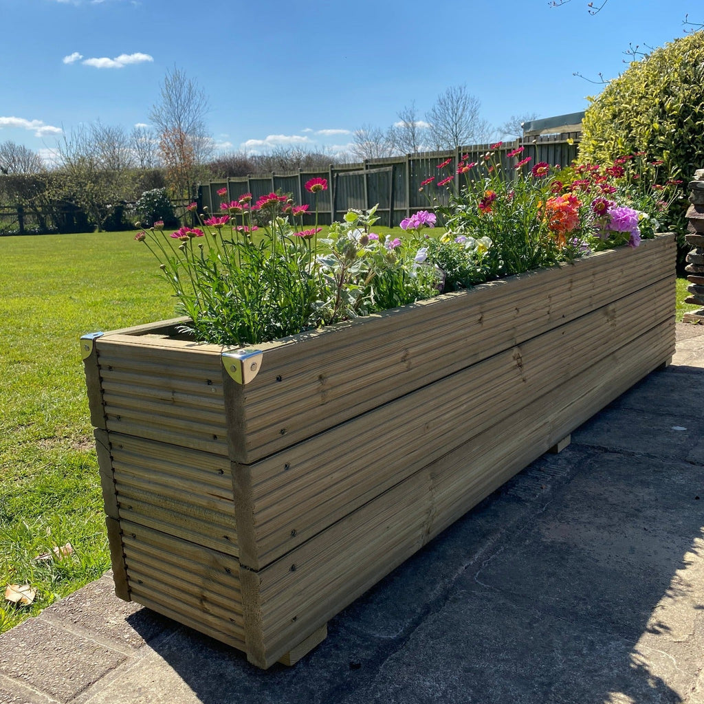 3 Boards High Deluxe timber Decking Planter With Flowers on a patio