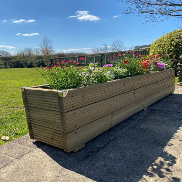 3 Boards High Deluxe timber Decking Planter With Flowers on a patio