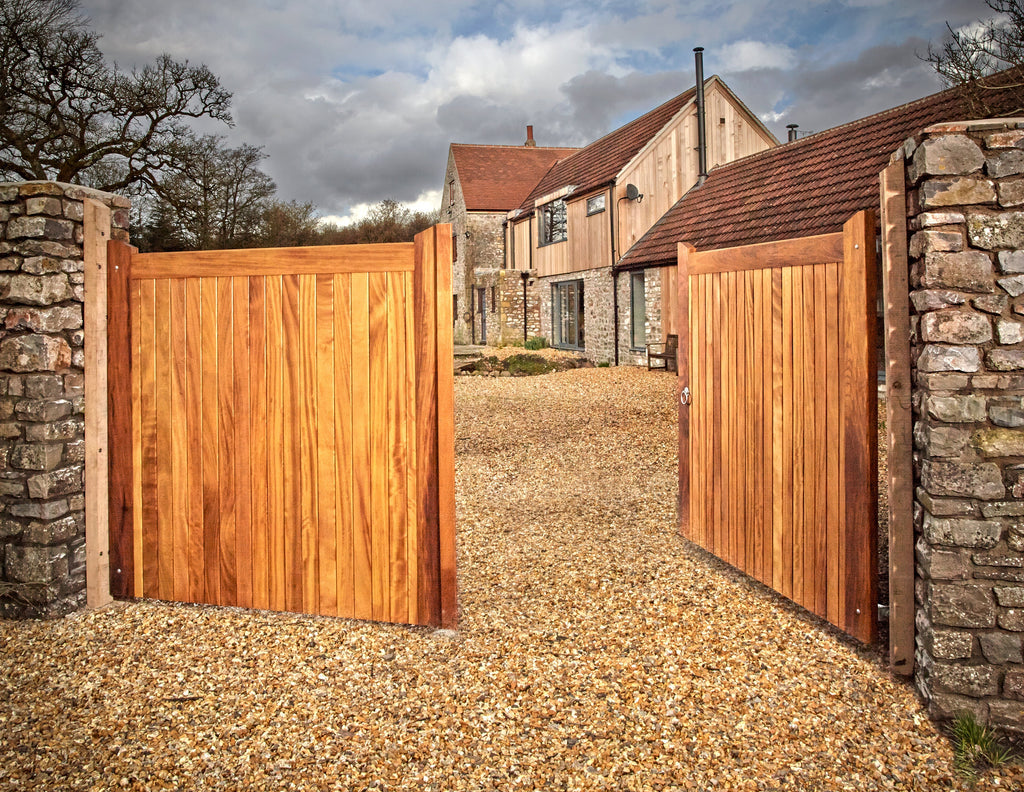 Iroko timber Highampton style mortise and tenon pair of entrance gates shown in a driveway
