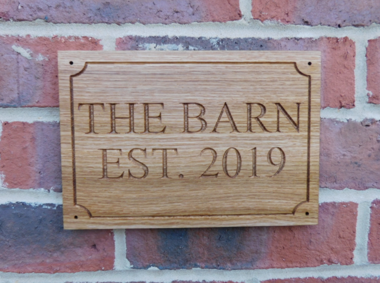 Hardwood Oak Entrance Sign on a brick wall