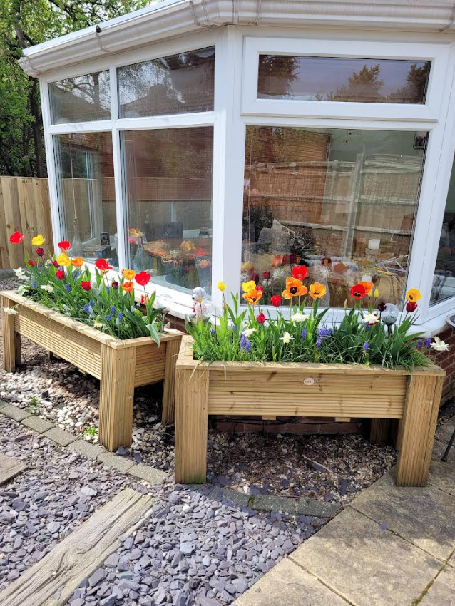 Premium timber decking raised planter in a garden with flowers