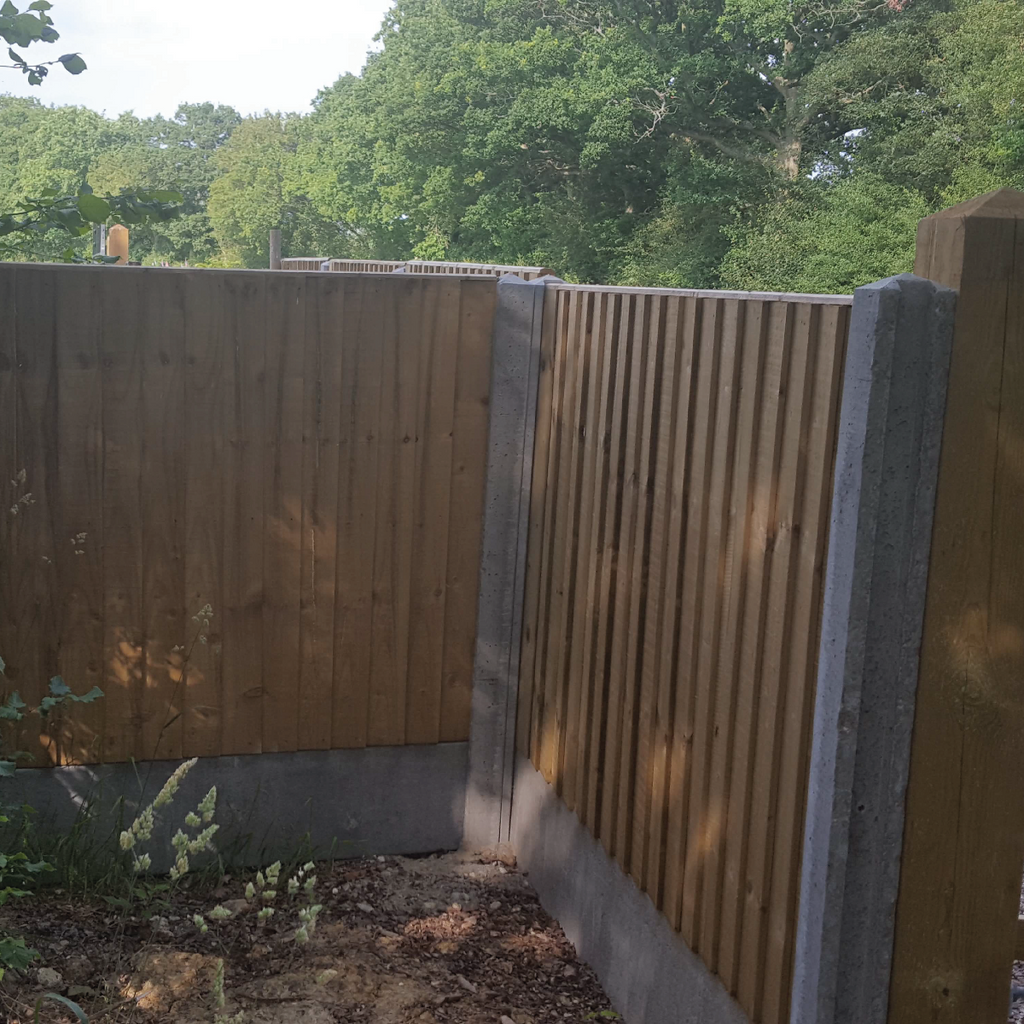 Concrete posts with featheredge fence attached in a garden